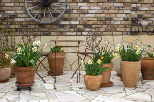beautiful place in the garden in the mediterranean style, clay pots with spring flowers