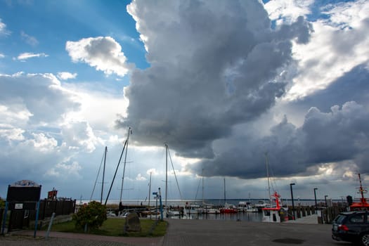 Timmendorf Strand, Germany, September 9, 2022 - Harbor with boats and a large imposing cloud at Timmendorf Strand, on the island of Poel, Mecklenburg-West Pomerania