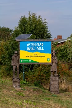 Insel Poel, Germany, September 9, 2022 - Wooden figures with welcome sign to the Insel Poel in Mecklenburg-Vorpommern, Germany