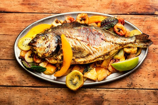 Delicious fried fish carp with fruits. Seafood