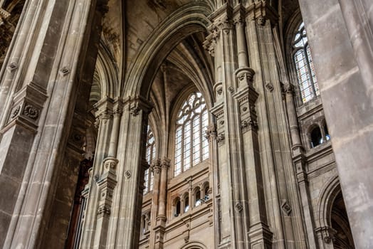 Tall columns and beautifully ornate ceiling in the gothic church Saint Eustache in Paris, France