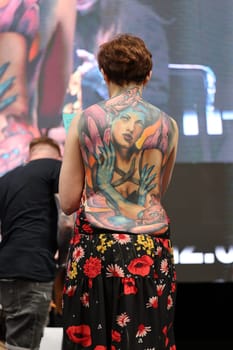 Krakow, Poland - June 12, 2022: Unidentified participant during the contest for the best tattoo at the 15th Tattoofest Convention in Cracow. One of the most prestigious tattoo festivals.