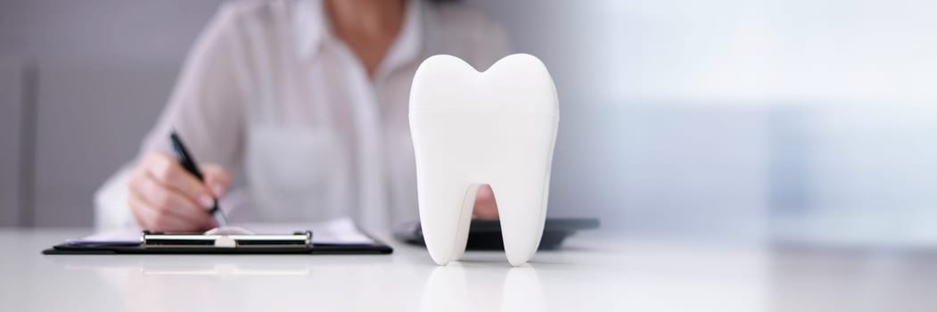 Dentist Paperwork At Desk In Front Of Teeth