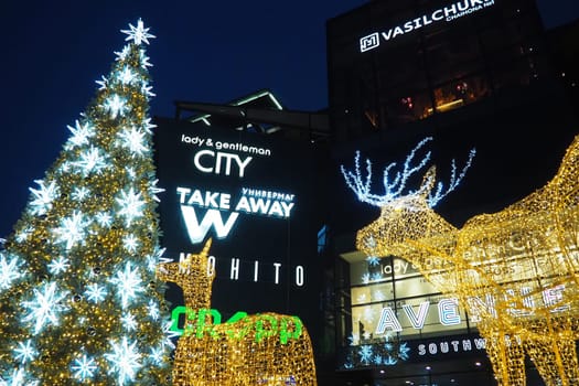 Moscow, Russia, January 17 2023 Street Christmas tree with snowflakes and festive balls. Metro Yugo-Zapadnaya. Christmas decorations in front of the mall. Silver stars, snowflakes and golden deers.