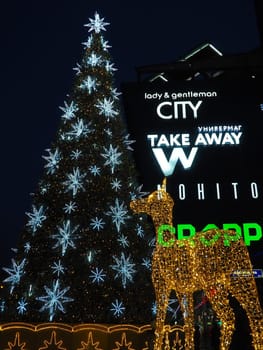 Moscow, Russia, January 17 2023 Street Christmas tree with snowflakes and festive balls. Metro Yugo-Zapadnaya. Christmas decorations in front of the mall. Silver stars, snowflakes and golden deer.
