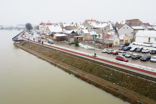 Sremska Mitrovica, Serbia 01.27.2023 View from the bridge over the Sava River. Flooding after heavy rains and snowmelt. Muddy water. Winter cityscape. People go and ride bicycles, cars go. Embankment