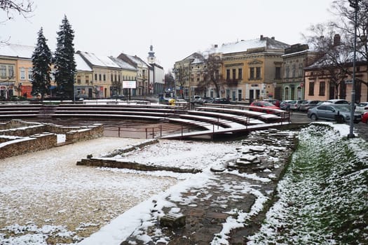 Sremska Mitrovica Serbia 01.27.2023 Snowfall in the city. Zhitni trg historical square. Ancient multi-colored buildings and excavations of Roman times. Weather forecast. Day winter. Cultural heritage