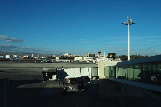 Ankara, Turkey, Esenboga Havalimani airport, 01.19. 2023 View from the window of the passenger terminal on the runway area. Airplane bridge. Tower with antenna. Airport building, boarding gate. Clouds