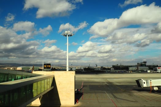 Ankara, Turkey, Esenboga Havalimani airport, 01.19. 2023 View from the window of the passenger terminal on the runway area. Airplane bridge. Tower with antenna. Airport building, boarding gate. Clouds