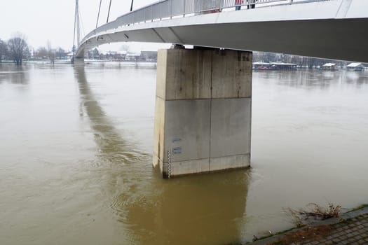 Sremska Mitrovica, Serbia, 01.27.2023 Bridge over the river Sava. Flooding after heavy rains and melting snow. A swift flow of muddy water. Hydrological scale for measuring the level of water