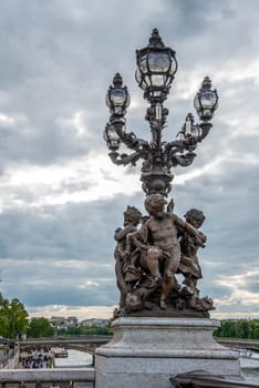 Ornate classicist Street Light with three Cherub on bridge Alexandre III, Paris, France