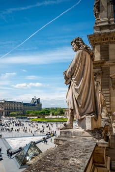 Statue looking down at the Square of Louvre Palace, Paris France