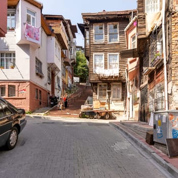Istanbul, Turkey - August 28, 2022: Beautiful old traditional wooden and stone houses, and stone staircase, in old Balat district, on a summer day