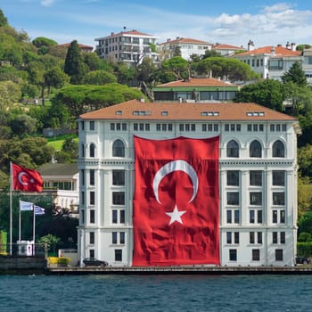 Traditional old waterside mansion, with huge Turkish Flag, suited in the Asian side of Bosphorus Strait, in Uskudar neighborhood, Istanbul, Turkey