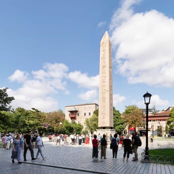 Istanbul, Turkey - August 30 2022: Tourists visiting the Obelisk of Theodosius, ancient Egyptian obelisk of Pharaoh Thutmose III re-erected in the Hippodrome of Constantinople, or Sultanahmet Square