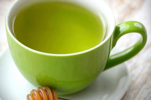 A vibrant green cup holds warm green tea, accompanied by a drizzle of honey, inviting relaxation and tranquility during midday.