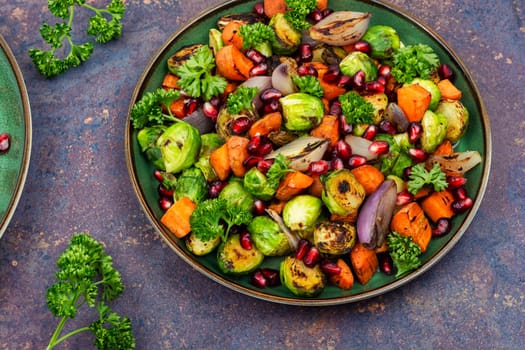 Salad with Brussels sprouts, carrots, with parsley and pomegranate seeds. Healthy vegetarian food
