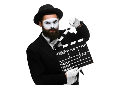 man in the image mime, dressed in black and white suit with movie board, isolated on a white background