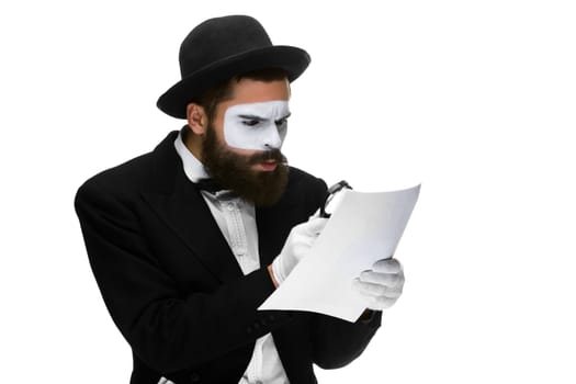 Man with a face mime reading  through a magnifying glass isolated on a white background. concept careful search