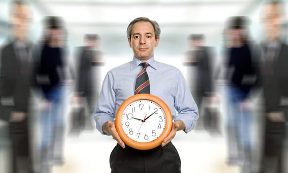 mature handsome business man holding a clock