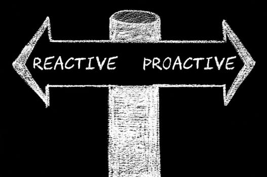 Opposite arrows with Reactive versus Proactive. Hand drawing with chalk on blackboard. Choice conceptual image