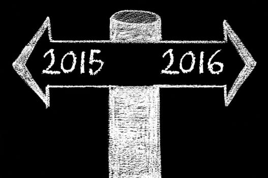 Opposite arrows with Year 2015 versus Year 2016. Hand drawing with chalk on blackboard. Choice conceptual image