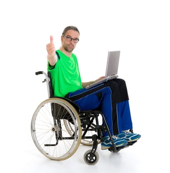 young man in a wheelchair in front of white background with computer and thumb up