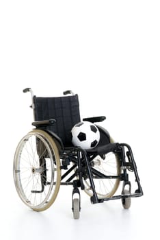 wheelchair with ball in front of white background