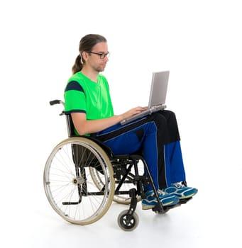 young man in a wheelchair in front of white background with computer