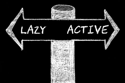 Opposite arrows with Lazy versus Active. Hand drawing with chalk on blackboard. Choice conceptual image
