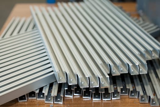 A series of aluminum profiles stacked on a table