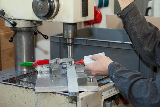 Metal workpiece is drilled with the addition of drilling oil