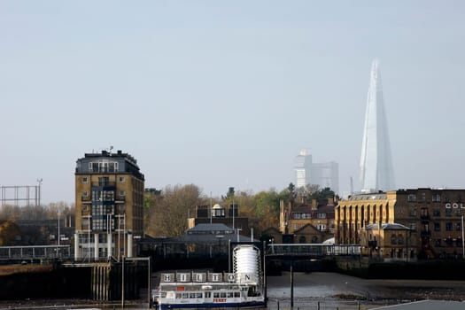 London,Uk – November 29,2014: The ferry stop of the Hilton Hotel on the banks of the Thames with the high-rise The Shard in the background on 29 November 2014 in London.