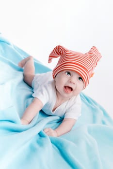 Baby in hat lying on a blue plaid