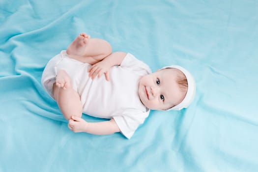 Baby in hat lying on a blue plaid