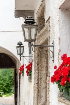 Street Lamp and Red Flowers at the Entrance of Monastery Hoeglwoerth, Bavaria, Germany