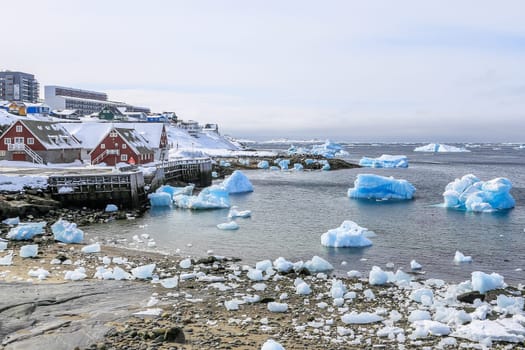 Nuuk old harbor panorama with blue icebergs drifting in the lagoon, Nuuk, Greenland
