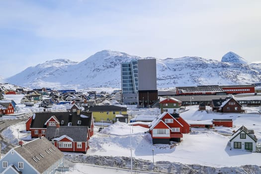 Nuuk city center streets with colorful Inuit houses covered in snow Nuuk with mountains in the background, Greenland