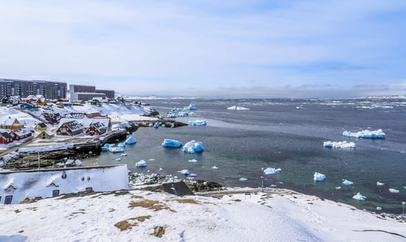 Nuuk old harbor panorama with blue icebergs drifting in the lagoon, Nuuk, Greenland