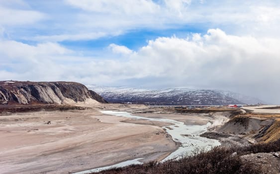Autumn greenlandic wastelands landscape with glacier river bend and mountains in the background, Kangerlussuaq, Greenland