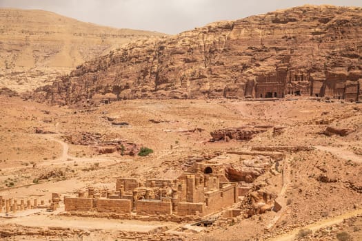 Ancient Nabataean Royal tombs in the background and ruins of grand temple in the foreground, Petra, Jordan