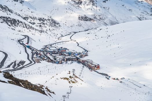 Roads going and out Pas de la Casa town in the valley between snow capped mountains. Ski winter holidays in Andorra, Pyrenees, Grandvalira