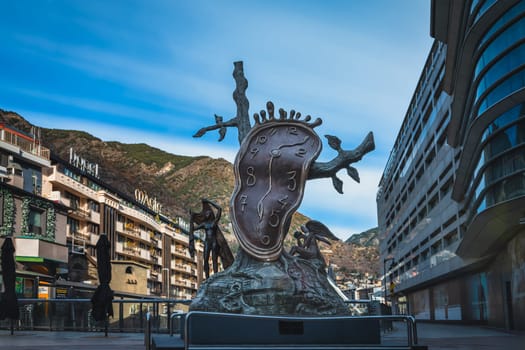 Andorra la Vella, Jan 2020 Noblesa del temps, Nobility of time, sculpture by Salvador Dali, melting clock and angels. Long exposure, stretched clouds