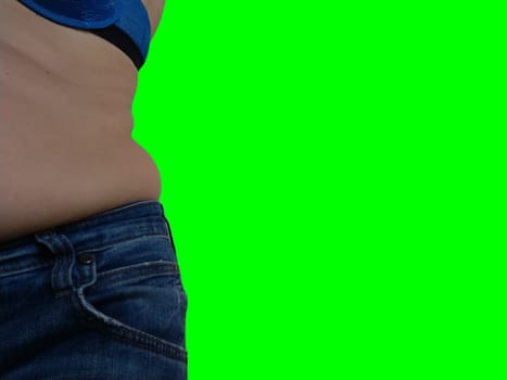 Saggy belly. Folds of leather and fat on the sides hanging over the waist of the jeans. Overeating or pregnancy. Obesity and Diabetes. Green chroma key background. Cellulite flabby muscles.