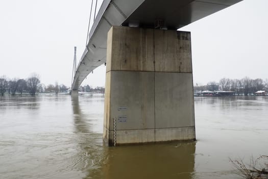 Sremska Mitrovica, Serbia, 01.27.2023 Bridge over the river Sava. Flooding after heavy rains and melting snow. A swift flow of muddy water. Hydrological scale for measuring the level of water
