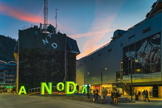 Andorra la Vella, Jan 2020 People watching iconic neon letters forming sign Andorra at night, Pyrenees Mountains