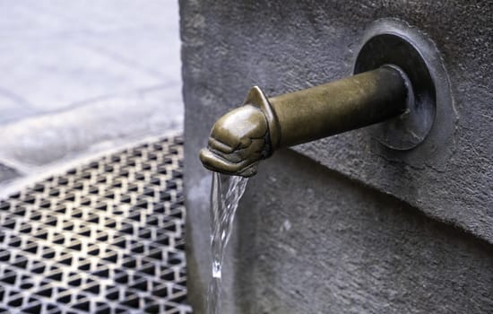 Detail of old fountain with water, decoration in the city