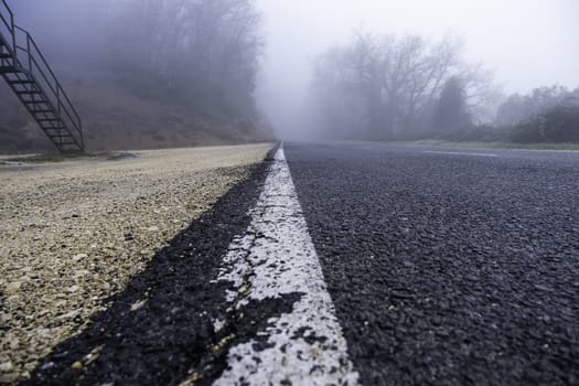 Detail of dark mountain road on a cold winter day, ice and snow