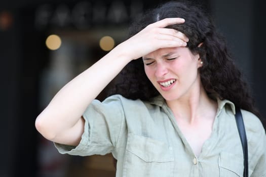 Woman complaining suffering migraine in the street