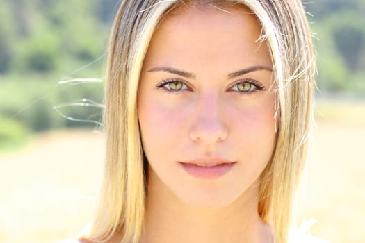 Front view portrait of a beautiful woman with green eyes looks at camera